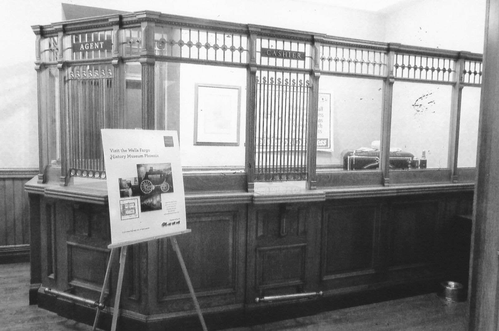 A 1920s bank tellers' cage of carved wood and brass bars
